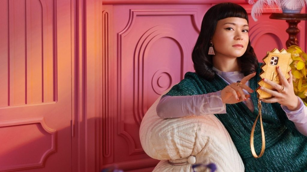 Les consommateurs français préfèrent faire leurs achats en magasin malgré leur volonté d’acheter davantage en ligne. Femme avec un smartphone, assise dans un fauteuil