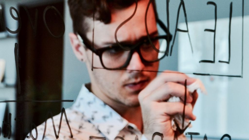 Conseils pour réussir une bonne prospection commerciale Homme devant un tableau de leads