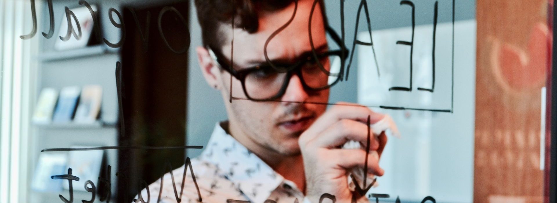 Conseils pour réussir une bonne prospection commerciale Homme devant un tableau de leads