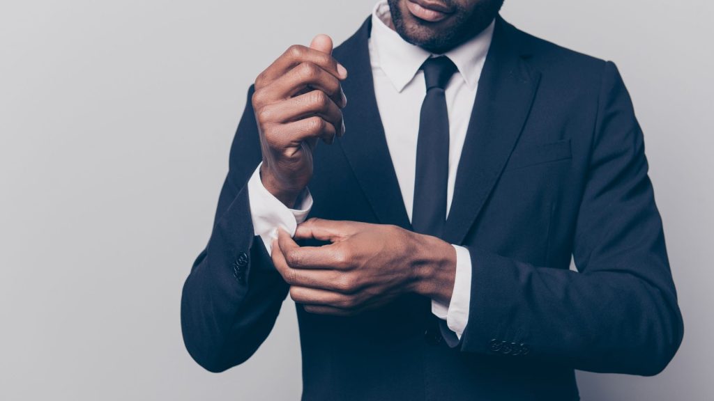 Le point sur les règles à suivre pour réussir ses RDV professionnels Homme en costume ajustant sa chemise