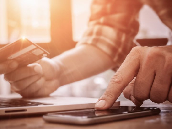 Homme effectuant un règlement en ligne avec sa carte bancaire