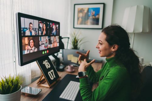Jeune femme en télétravail fait une vidéoconférence avec ses collègues