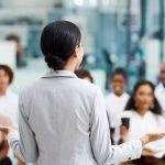 femme faisaint un disocurs devant un groupe de personnes