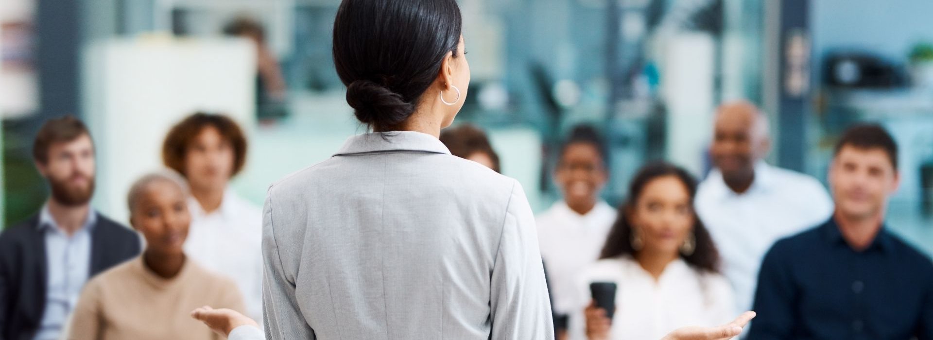 Quelles solutions peuvent apporter dirigeants et managers pour redonner du sens à leurs collaborateurs ? femme faisaint un disocurs devant un groupe de personnes