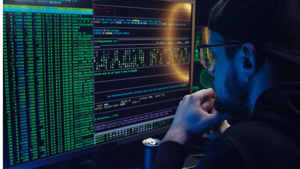 Homme devant l'écran d'un PC avec des lignes de codes