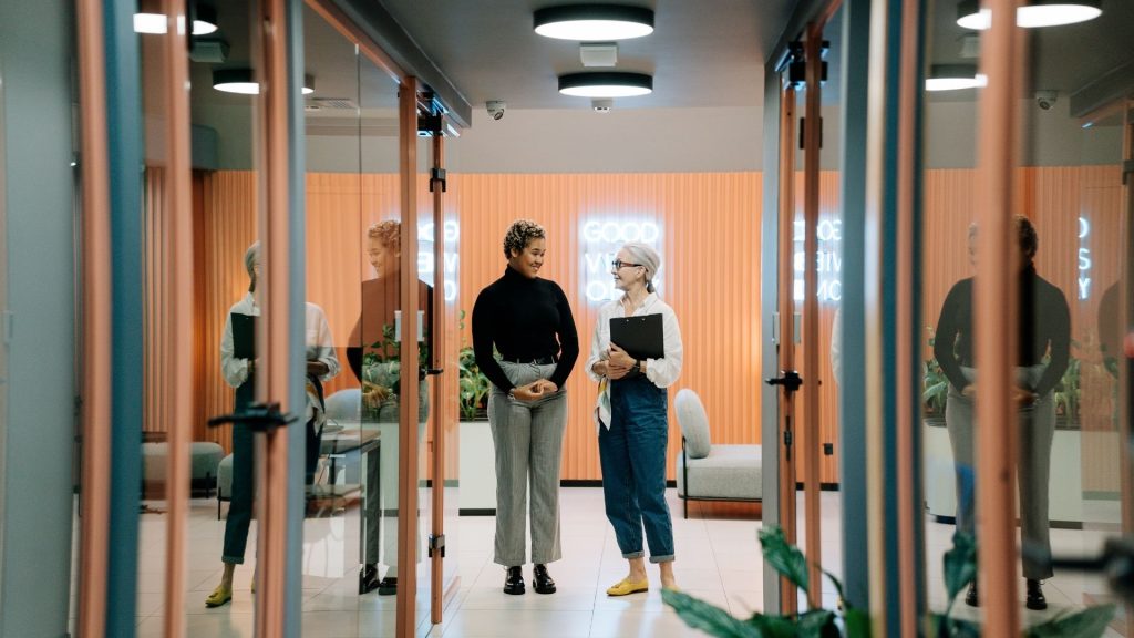 ENACO ouvre une trentaine de postes avec pour objectif de créer environ 100 emplois en CDI à fin 2022. 2 femmes échangeant dans un couloir