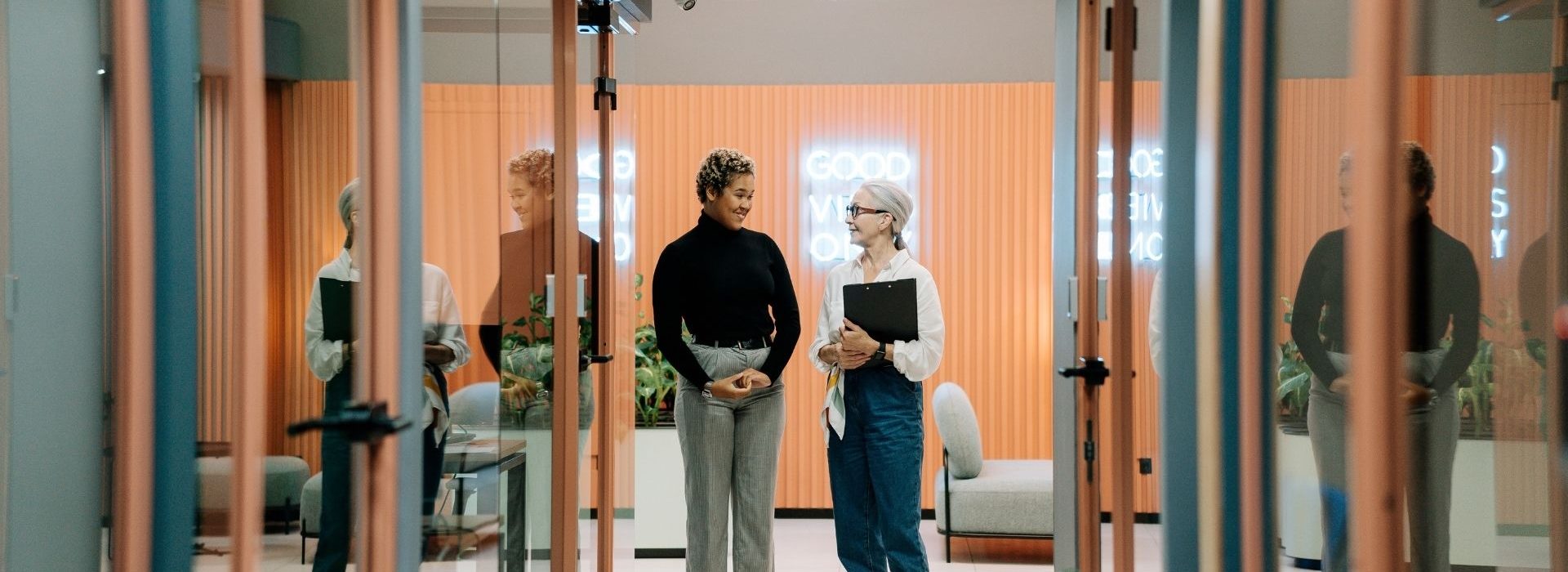 ENACO ouvre une trentaine de postes avec pour objectif de créer environ 100 emplois en CDI à fin 2022. 2 femmes échangeant dans un couloir