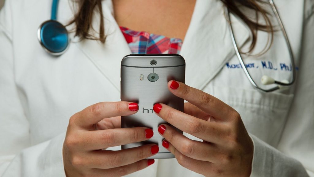 Docteur tenant un smartphone dans ses mains