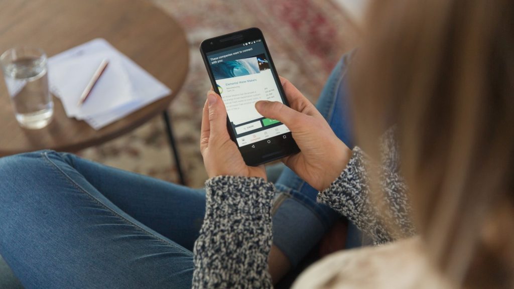 Bruce, agence d’emploi 100% digitale basée à Paris et à Barcelone, intègre sa raison d’être dans son statut juridique et devient une entreprise à mission. Femme consultant son smartphone