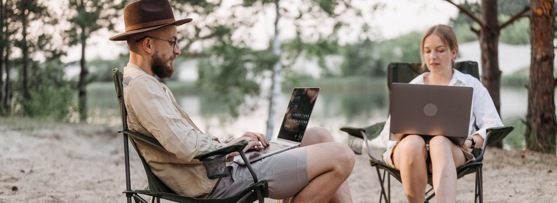 Télétravail : il est nécessaire d’accompagner, voire d’encadrer cette tendance lourde pour répondre efficacement aux nouveaux enjeux qui sont aujourd’hui posés. 2 personnes travaillant sur leur ordinateaur depuis une forêt