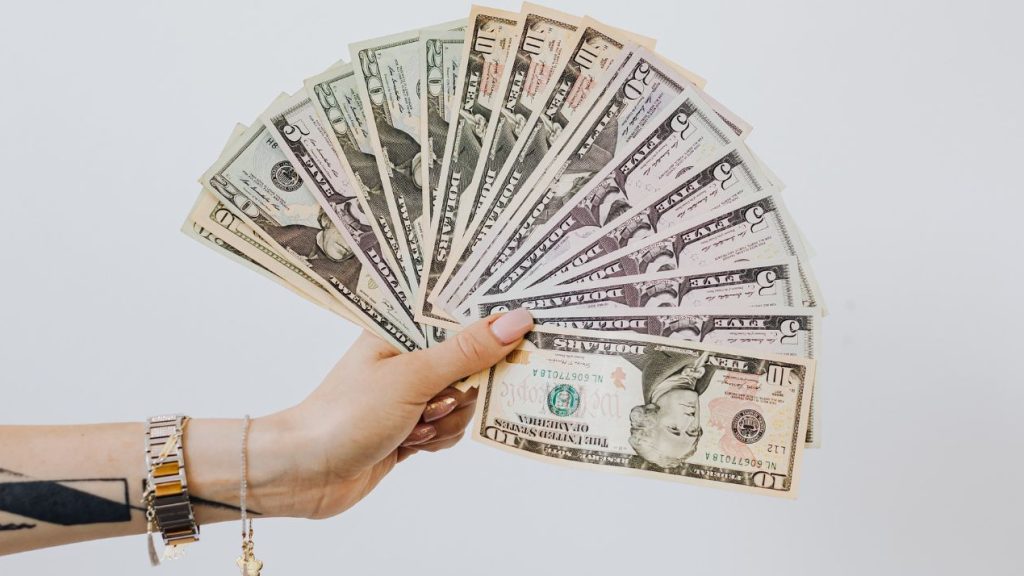 Comment établir une vraie stratégie autour de sa levée de fonds ? Bras tatoué tenant des billets