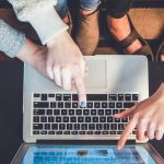 4 personnes montrant quelque chose sur un écran d'ordinateur