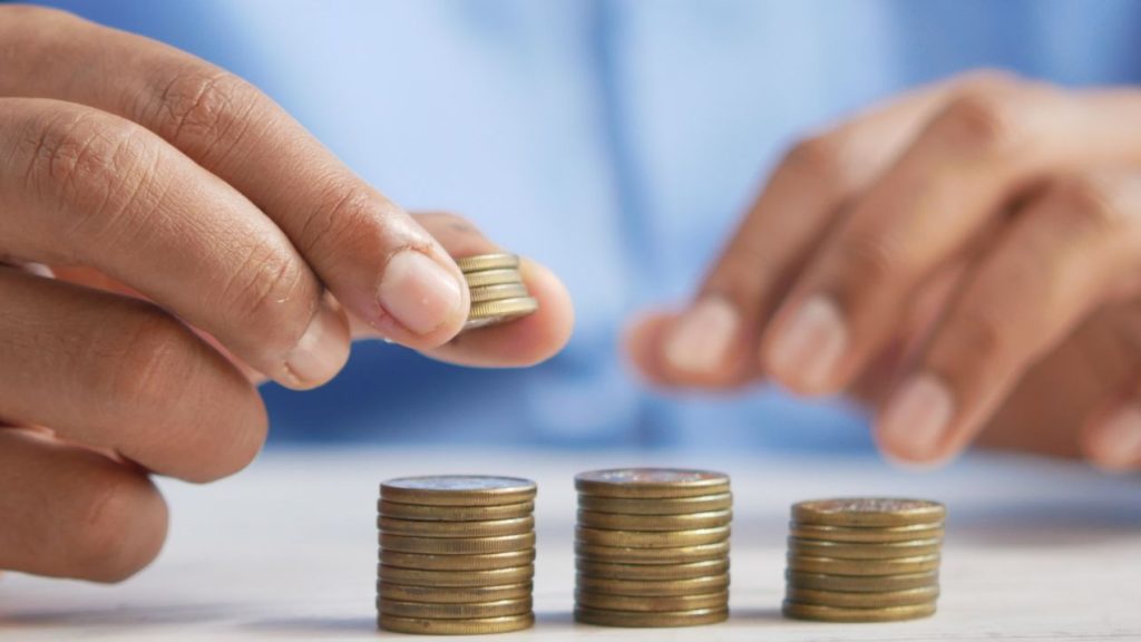 La période des négociations annuelles obligatoires s’ouvre dans un contexte un peu particulier : inflation, pénurie de candidats, grande démission... Homme faisant des petits tas avec des pièces de monnaie