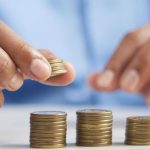 Homme faisant des petits tas avec des pièces de monnaie