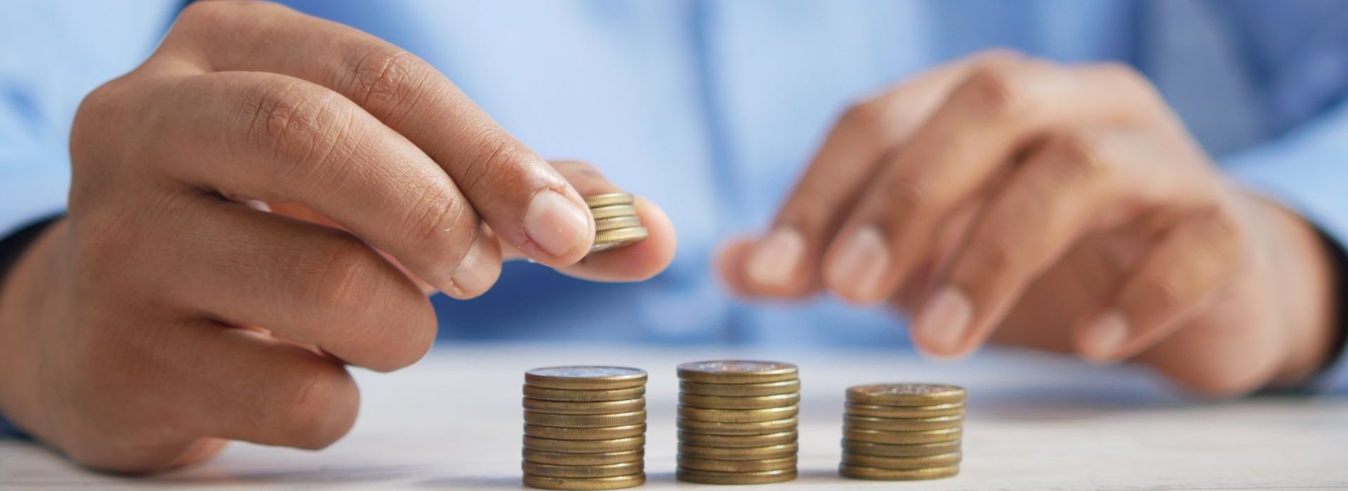 La période des négociations annuelles obligatoires s’ouvre dans un contexte un peu particulier : inflation, pénurie de candidats, grande démission... Homme faisant des petits tas avec des pièces de monnaie