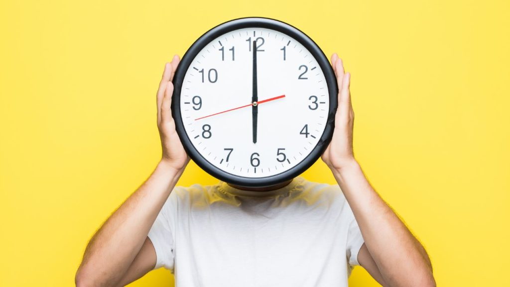 Timeboxing : qu'est-ce que c'est, ses avantages et comment ça marche ? Homme qui porte à la place de sa tête une horloge