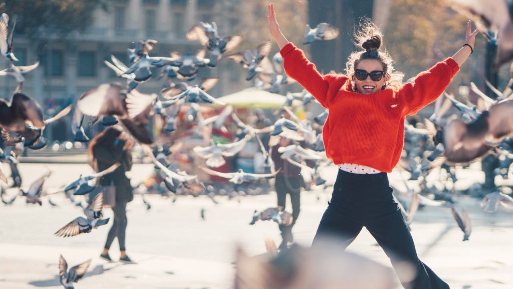 Femmes sautant au milieu d'oiseaux