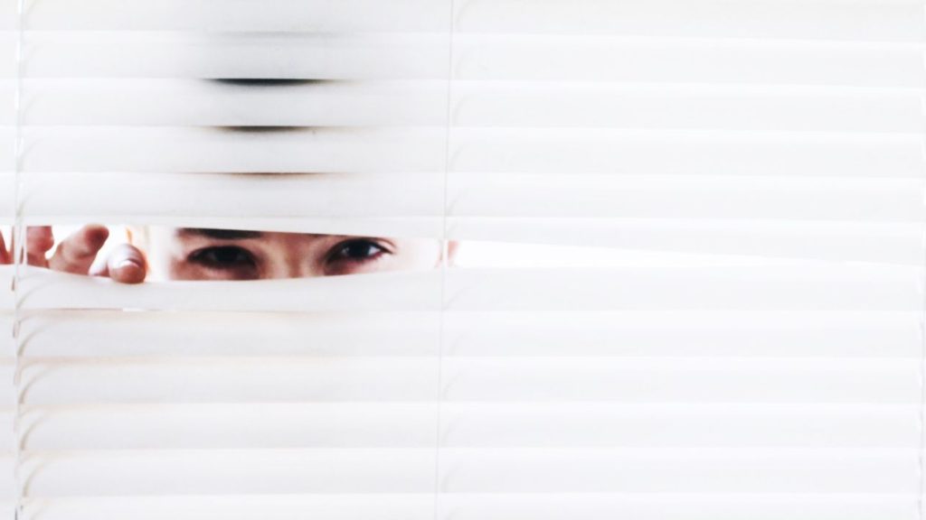 Une étude menée par Software Advice montre que de nombreuses entreprises ont recours à des outils de surveillance. Personne regardant à travers des persiennes