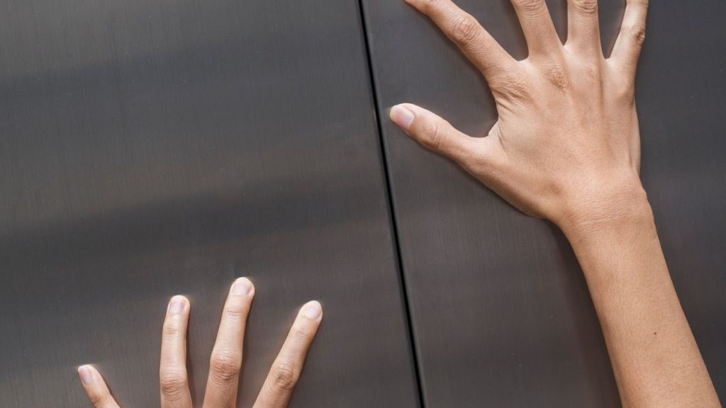 Mains sur les portes d'un ascenseur