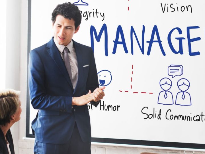 Quelles sont les compétences dont les cadres dirigeants ont besoin pour faire face aux défis actuels ? Jeune homme en costume devant un tableau sur lequel se trouve une carte mentale du management