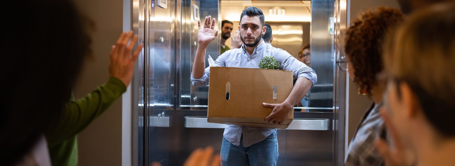 « Quick Quitting », notre travail est-il devenu une expérience à consommer ? Homme dans un ascenseur avec un carton dans les bras