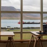 Femme travaillant devant une baie vitrée avec vue sur la mer