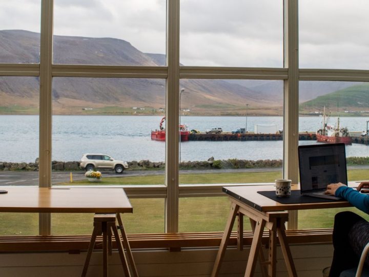 Femme travaillant devant une baie vitrée avec vue sur la mer