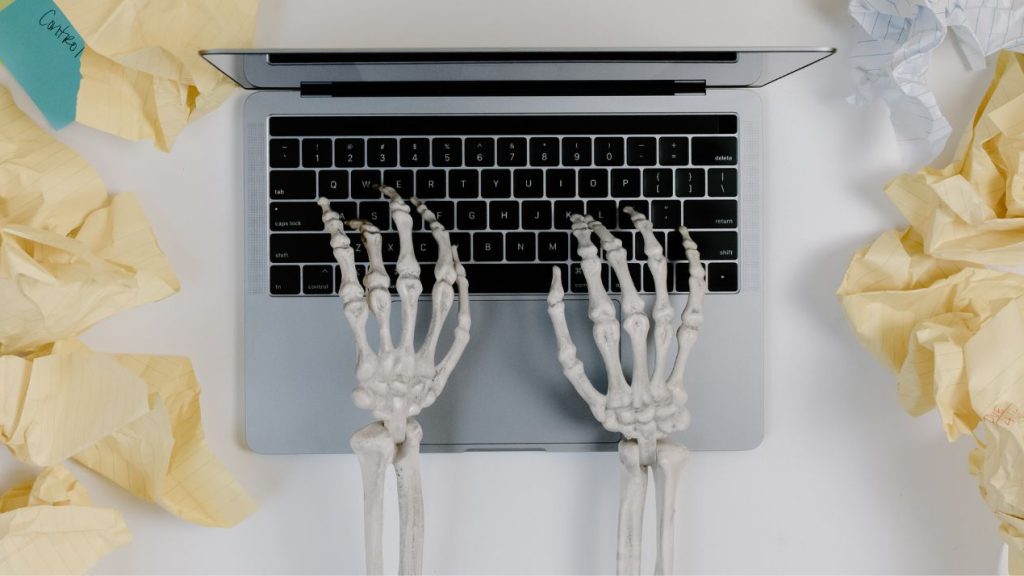 Quelles sont les conséquences du désengagement salarial en entreprise ? Mains d'un squelette sur un ordinateur