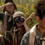 Enfant avec des jumelles et des loupes