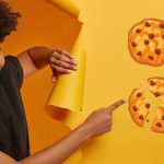 Femme souriante montrant du doigts 4 élements : un télévision, des cookies, une main d'intelligence artificielle et le logo whatsapp